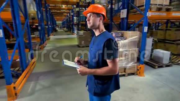 一个年轻严肃的仓库检查员在一个仓库设施工作视频的预览图