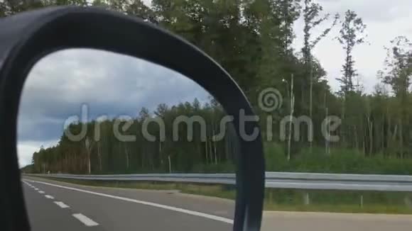 人在侧视镜中看道路在州际公路上驾驶汽车视频的预览图