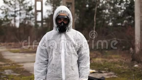 穿着生物危险服和防毒面具的人站在满是废物的地方的条纹后面视频的预览图