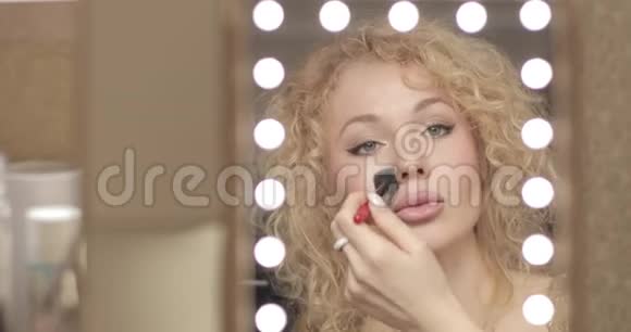 金发碧眼的看着镜子在家化妆视频的预览图
