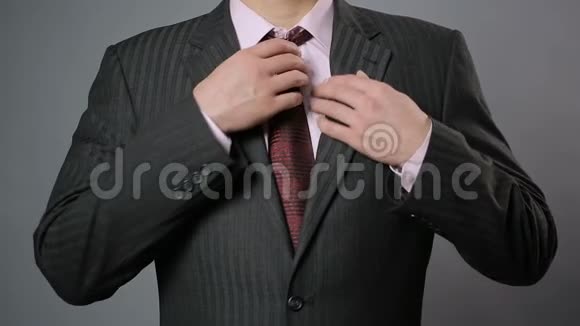 商人调整他的领带和夹克特写时尚男装视频的预览图