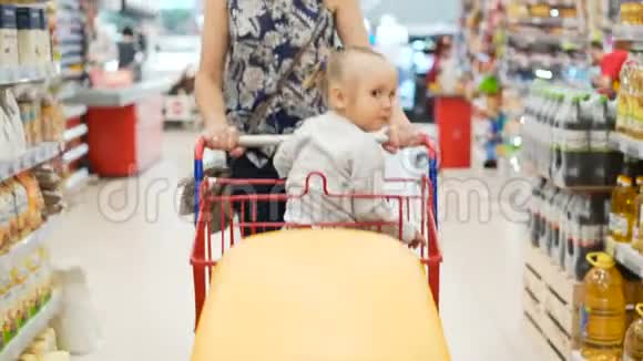 两个孩子在塑料购物车室内市场与木乃伊视频的预览图