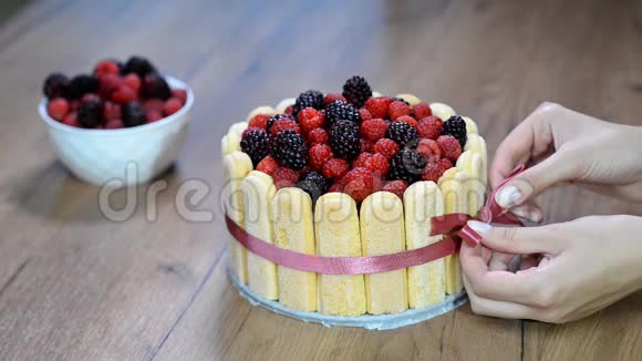 女人装饰法国夏洛特蛋糕与夏季水果在家庭厨房视频的预览图