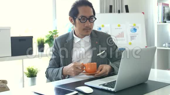 在办公室工作的商务人员在笔记本电脑上工作4K慢动作亚洲商务人员在办公室戴眼镜视频的预览图