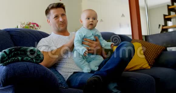 爸爸和小男孩在客厅看电视视频的预览图