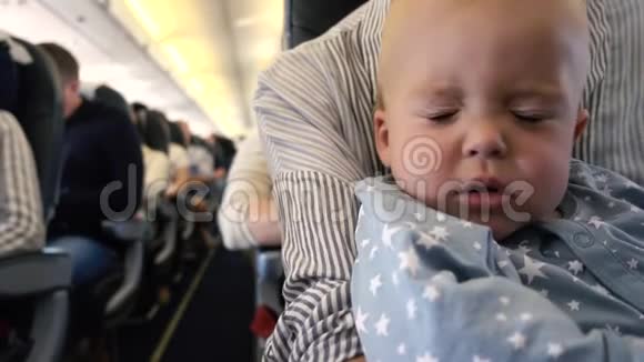 孩子在飞机上睡在妈妈手视频的预览图