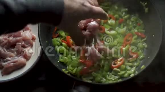 男人把鸡肉放在红辣椒和青椒上视频视频的预览图