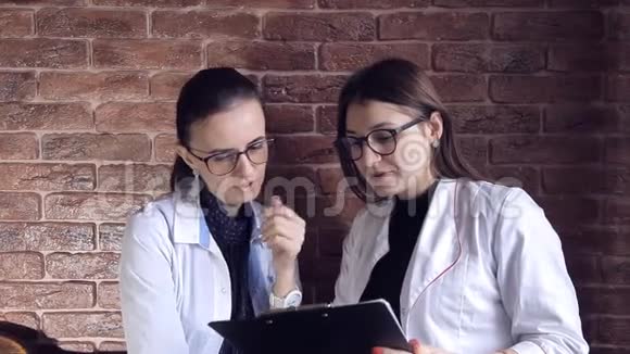 两名女医生在档案中查看医疗记录并咨询诊断智能专业保健视频的预览图