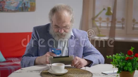 在咖啡馆买信用卡的资深退休人员视频的预览图