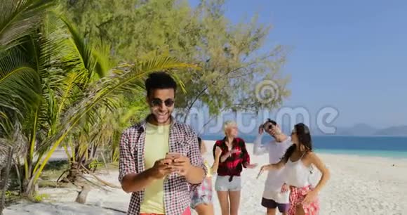 海滩上的人群使用手机聊天的西班牙裔美国人男人和女人跳舞视频的预览图