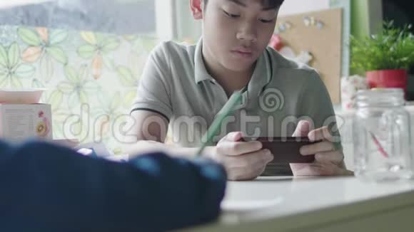 男孩在家里和朋友一起用数码平板电脑学习视频的预览图