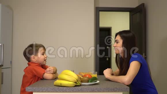 男孩在早餐时讲故事女人听他说视频的预览图