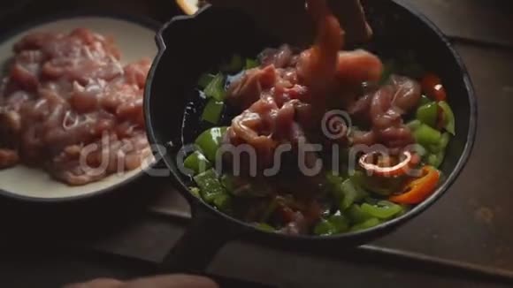 男人把鸡块放进一个加胡椒的煎锅里视频视频的预览图
