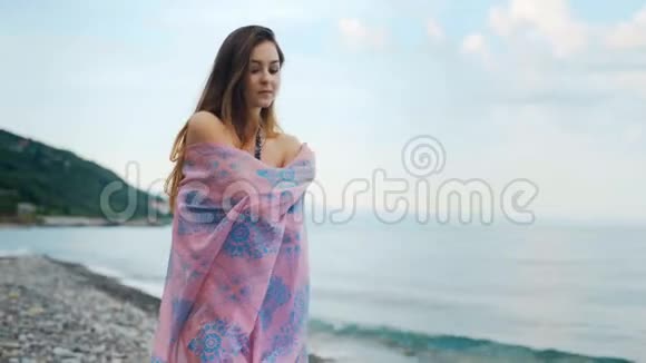美丽思考的女人沿着海岸线行走视频的预览图