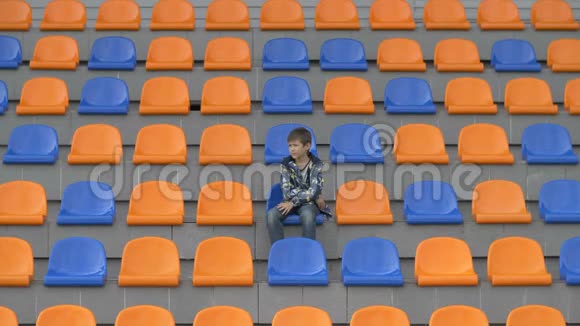 教练男孩坐在体育场很高兴他的球队进球了看体育场比赛的快乐男孩视频的预览图