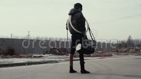 后启示录孤独的年轻女子走在垃圾场和被遗弃的城镇视频的预览图