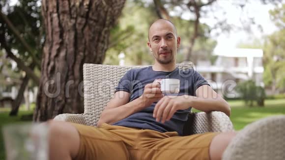 男人在智能手机上发短信在街头咖啡馆喝咖啡视频的预览图