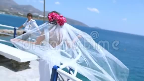 新娘新郎和新娘结婚后在海滩上面纱随风飘扬视频的预览图