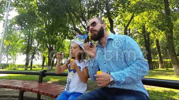 爸爸和女儿在公园里吹泡泡视频的预览图