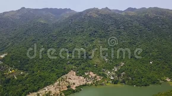 青山覆盖热带森林和湖泊鸟瞰图从飞行无人机俯瞰高山和湖泊海岸线视频的预览图