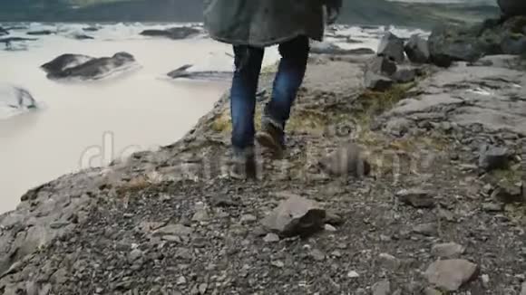年轻英俊的男人在冰岛的瓦特纳霍卡尔冰湖附近的山上穿过岩石视频的预览图