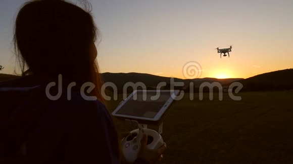 太阳落山时使用四重机遥控射击视频的年轻快乐女孩高清慢速运动视频的预览图