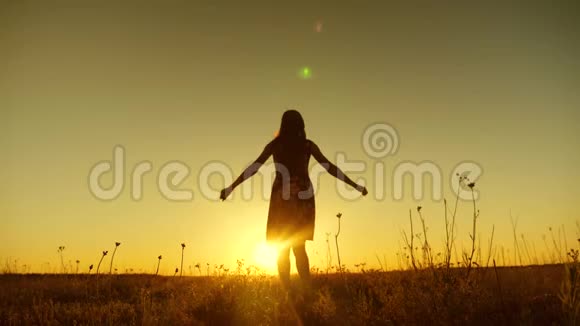 一个女孩正在金色太阳的夕阳下跳跃慢动作视频的预览图