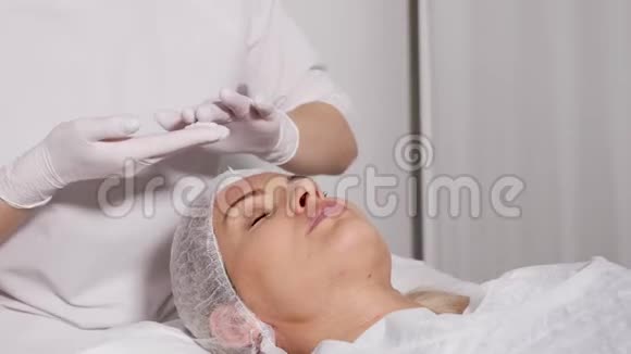 医生美容师给躺在特殊桌子上的病人卸妆视频的预览图