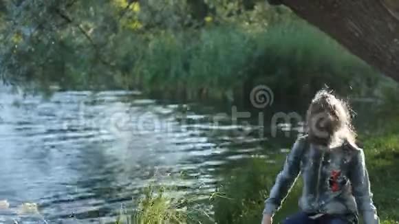 一个女孩在湖边的公园里玩视频的预览图