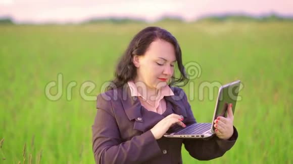 大自然中的女人在笔记本电脑上谈论视频会议视频的预览图