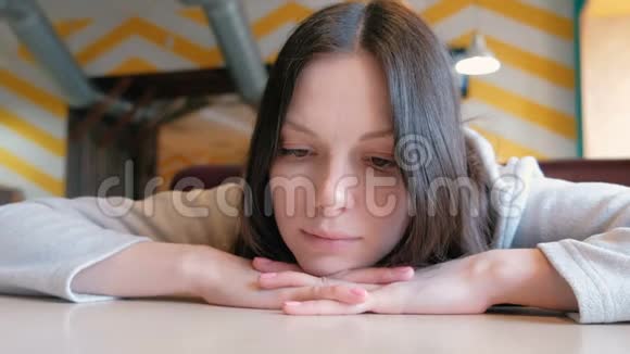 悲伤的女人坐在咖啡馆里等待她的命令微笑着特写的脸视频的预览图