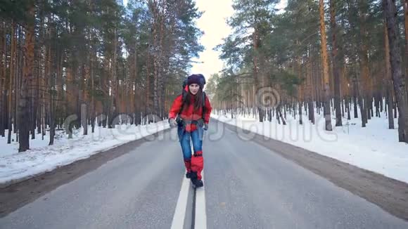 迷人的游客在森林的冬天的道路上尽情地跳舞看着镜头视频的预览图