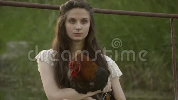 白衣少女拥抱公鸡乡村生活视频的预览图