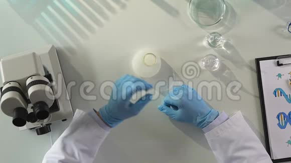 男性实验室辅助混合液体试剂监测化学反应视频的预览图