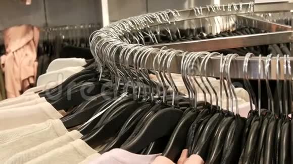 在大圆衣架上有各种时尚的针织多色毛衣挂在时尚的黑色衣架上视频的预览图