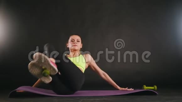 年轻的健身女性用哑铃做腿部训练在工作室吸引人的健身模特视频的预览图