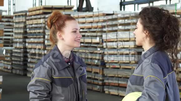 年轻快乐的女工厂工人在仓库里忙碌着视频的预览图