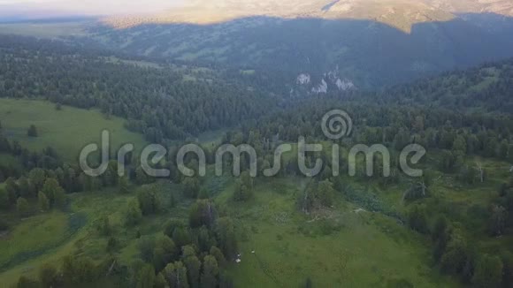 美妙的飞行到美丽的山谷与森林在山上剪辑美丽的绿色山谷环绕着视频的预览图