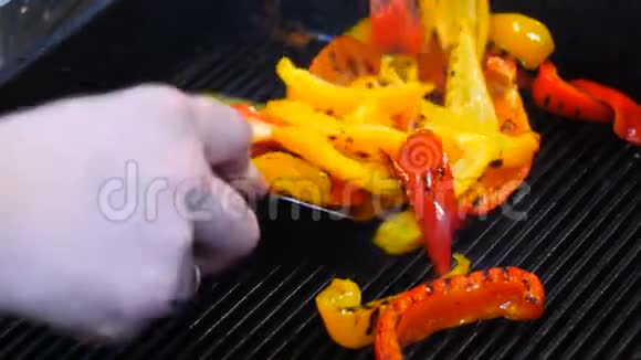 将五彩椒切成薄片放入煎锅中准备好的烤架厨师拿出一个胡椒烤架视频的预览图