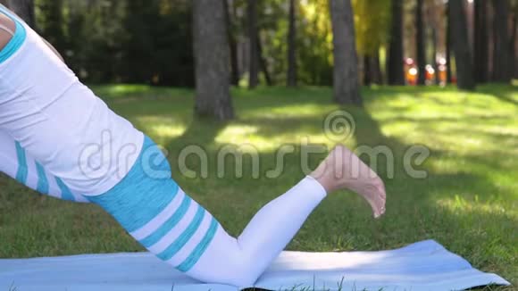 在公园里做瑜伽的女人双腿合拢健康的生活方式视频的预览图