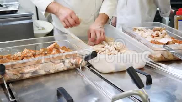厨师在餐厅的厨房里放了很多切碎的鸡肉或火鸡片腌制成白色视频的预览图