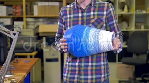 这个人拿着一个3D打印机上做的花瓶4K视频的预览图