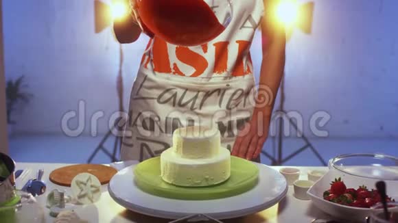 白色圆形双层蛋糕被红色的大量奶油覆盖视频的预览图