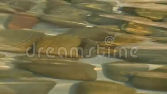 水下的石头和水面上的涟漪清水下的卵石藻类覆盖的石头视频的预览图
