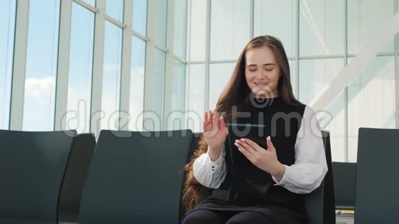 乘客旅客女士在机场等待航空旅行使用平板智能手机年轻的商界女性视频的预览图