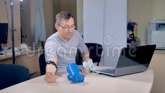 一位工程师教一个仿生手原型制作拳头视频的预览图