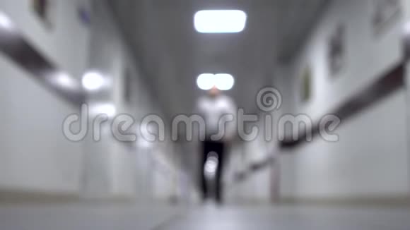 一个人沿着走廊走背景模糊年轻人走在长长的走廊上视频的预览图