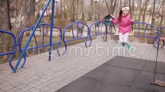 公园里的春游操场上的小女孩骑着秋千视频的预览图