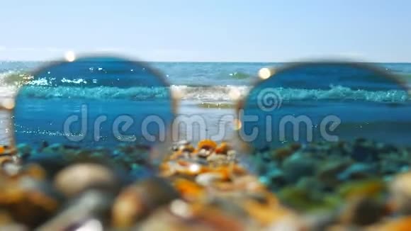 太阳镜留在贝壳海滩上专注于大海视频的预览图