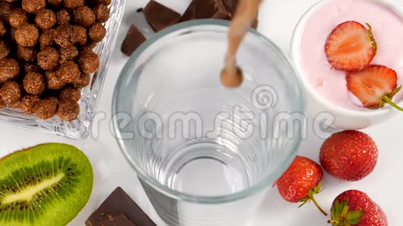 巧克力牛奶在玻璃中流动作为早餐视频的预览图